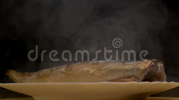 在黑色背景上用冷冻鲭鱼制作的盘子上面有霜冻的新鲜和蒸发特写4K视频的预览图