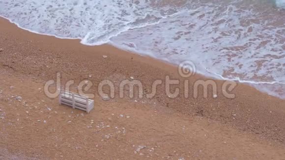 一张孤独的白色木凳矗立在沙滩上视频的预览图