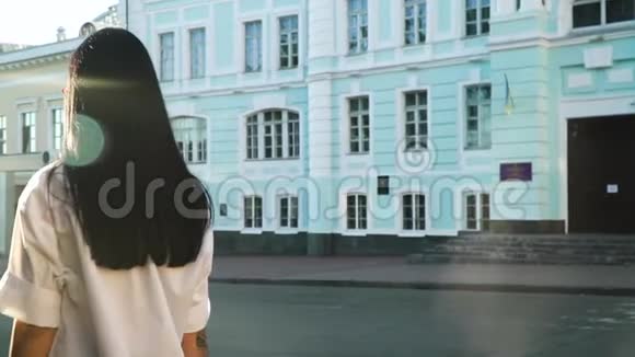 身着白色衬衫的长发黑发女子正缓慢地从镜头前向前移动视频的预览图