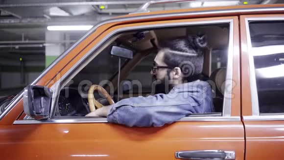 一个长着长发长着大胡子的英俊男子望着车窗外驱车离开视频的预览图