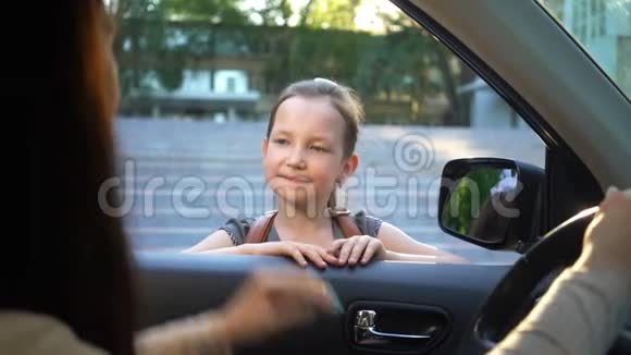 年轻的母亲坐在车里送女儿上学视频的预览图
