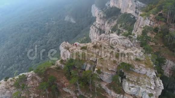 高空俯视图夏日游客坐在山顶悬崖上视频的预览图