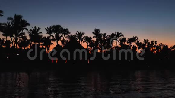 日落时的热带海滩浪漫的夜晚泛着海水的灯光视频的预览图