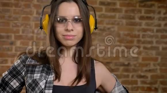 戴眼镜戴耳机在摄像机前摆姿势转身走开女建筑工人砖匠视频的预览图