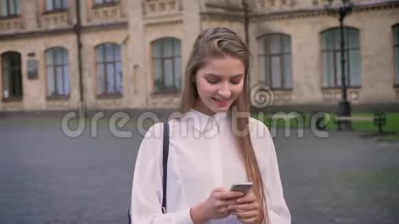 年轻漂亮的女孩在夏天在智能手机上输入信息思考过程交流观念视频的预览图
