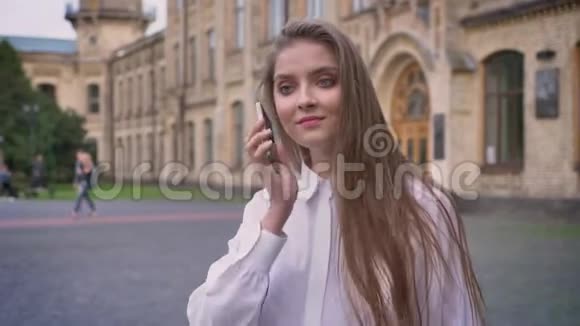 年轻漂亮的快乐女孩在夏天白天打电话上大学沟通观念视频的预览图