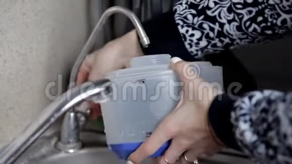 女孩把水收集在一个塑料容器里专门为蒸汽熨斗和蒸汽机设计视频的预览图