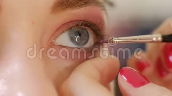 化妆师用眼影化妆来塑造的眼睛关闭视野烟熏的眼睛左视图慢动作化妆视频的预览图
