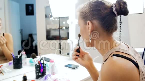 美丽的年轻女性时装模特在视觉工作室里化妆照镜子的慢动作视频视频的预览图
