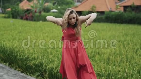 身材苗条身材苗条的模特表演一支温柔的独舞身穿一件红色长裙留着一个发型视频的预览图