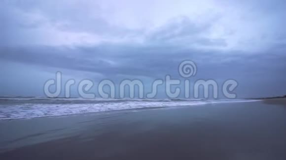 没有人的海滩沐浴在蓝色黄昏照亮的海浪中视频的预览图