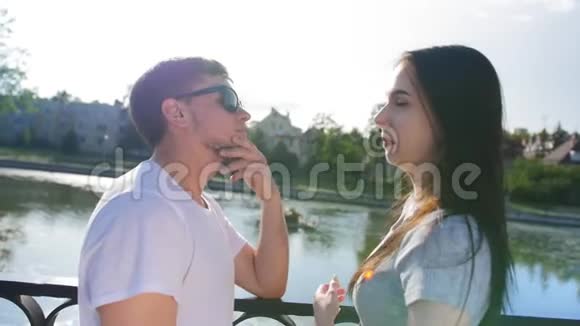 年轻漂亮的夫妇站在桥上的公园里聊天中弹视频的预览图