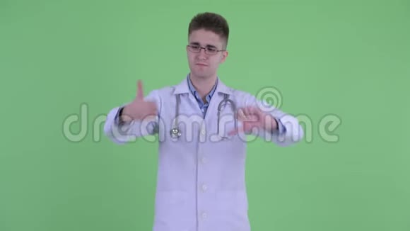 一位困惑的年轻医生在竖起大拇指和竖起大拇指之间做出选择视频的预览图