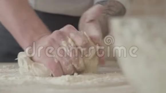 在现代厨房里年轻的披萨制造商在家里用均匀的揉面团做披萨食物概念视频的预览图