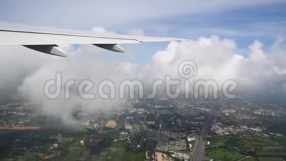 飞机在城市上空的云层中飞行飞机机翼紧贴地面视频的预览图