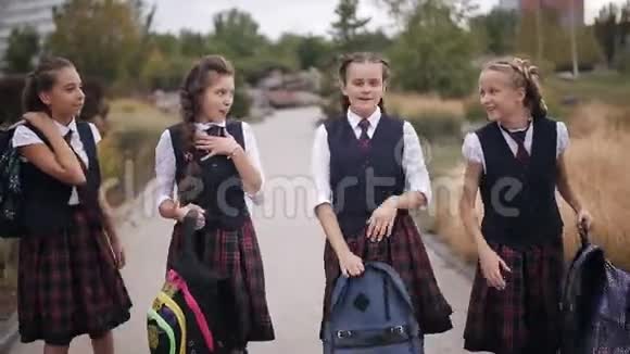 穿着同样校服的女学生背着背包在公园里嬉笑打闹视频的预览图