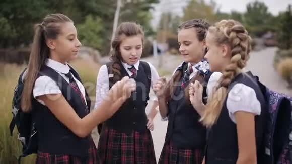 年轻学生玩石头剪刀可爱的女学生夫妇穿着校服玩得很开心视频的预览图