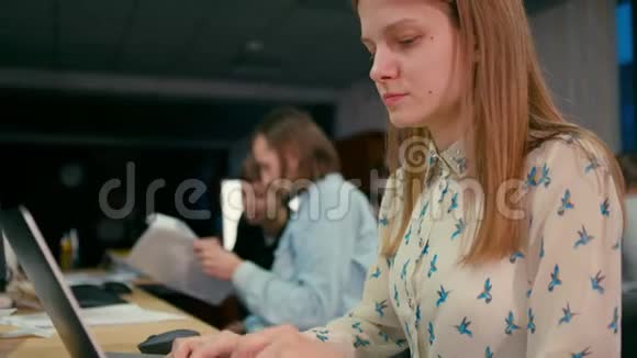 4年轻女子正在办公室的笔记本电脑旁工作视频的预览图