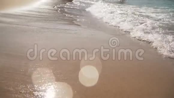 泡沫海波在阳光下闪闪发光平静地在沙滩上翻滚海浪一个接一个地覆盖着视频的预览图