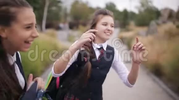 女学生放学后在街上玩得很开心穿着同样校服的女生笑着唱歌视频的预览图
