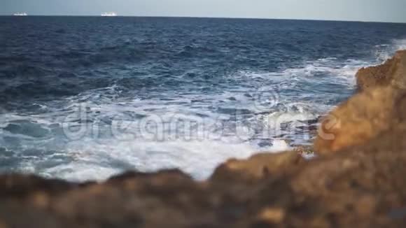 潮汐撞击形成白色海洋泡沫的石头水是干净纯净的视频的预览图
