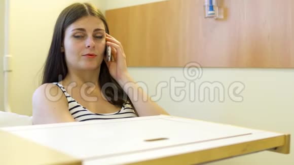 一个年轻女孩在医院的房间里打电话视频的预览图