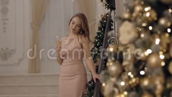 性感的年轻女子穿着粉红色的裙子看着酒杯微笑着视频的预览图