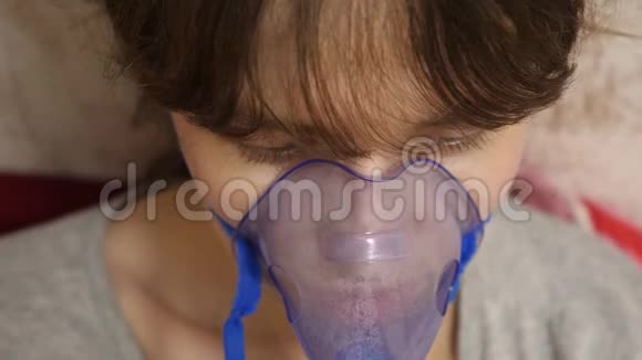 在一家医院里妇女脸上戴着吸入面罩坐在沙发上的喷雾器吸入了生病的女孩视频的预览图