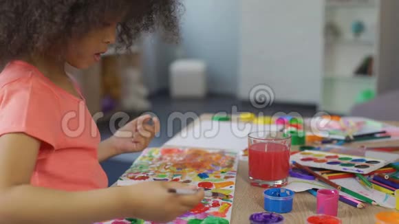 小非洲裔美国女孩在幼儿园练习绘画休闲活动视频的预览图