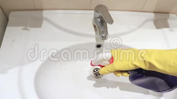 无法辨认的女人戴着黄色橡胶手套冲洗浴室水槽和水龙头用雨刷喷雾和泡沫清洁剂洒水视频的预览图