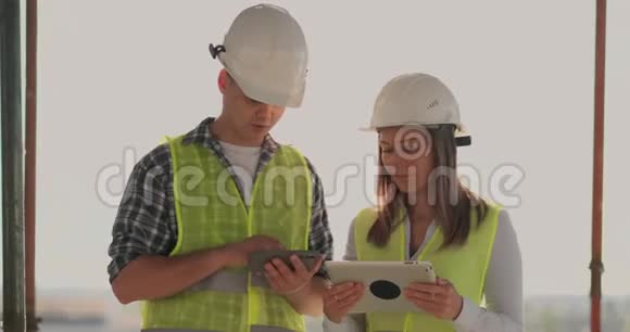 一栋在建建筑的主管男子与工程师设计师妇女讨论施工进度和视频的预览图