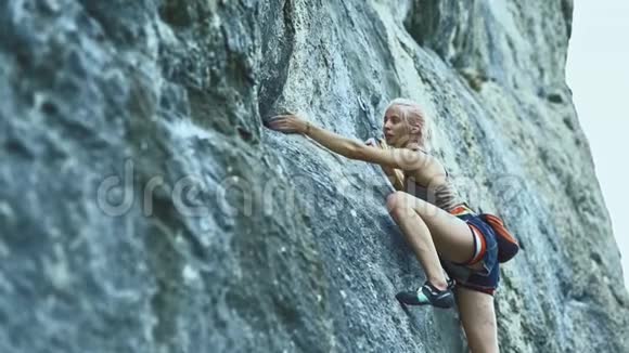 有彩色头发的运动妇女在山上攀岩视频的预览图