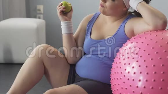 女士锻炼后坐在地板上吃苹果健康节食减肥视频的预览图