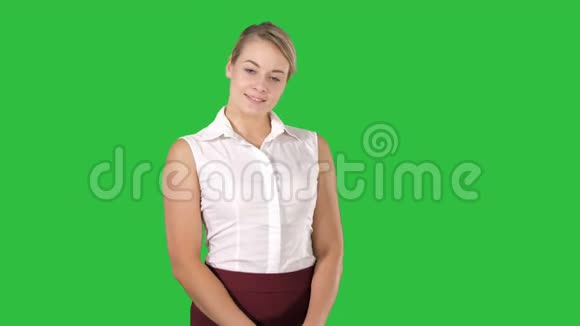 一个年轻漂亮的女孩站在绿色屏幕上显得害羞的肖像Chroma键视频的预览图