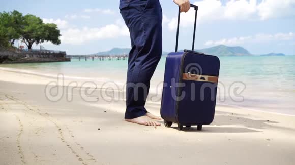 商人带着一个手提箱沿着美丽的大海的海岸散步男性快乐假期长期自由职业概念视频的预览图