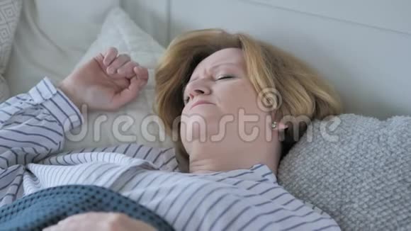 睡在床上头痛的老年妇女视频的预览图