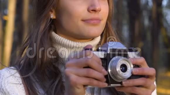 快乐的女孩在美丽的秋天公园拍照休闲和爱好视频的预览图