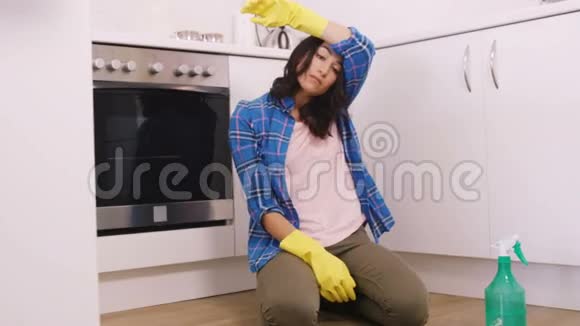打扫卫生时坐在地板上的疲惫的女人视频的预览图