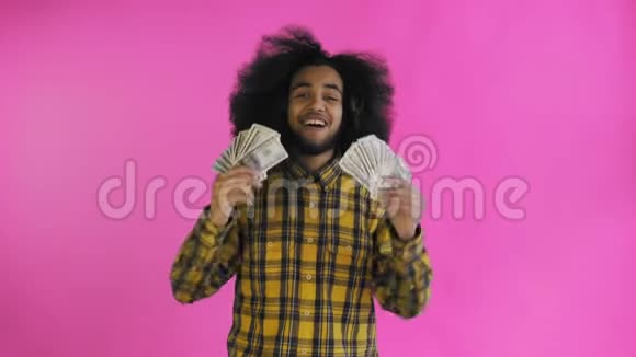 年轻的非洲裔美国男子持有现金在紫色背景视频的预览图