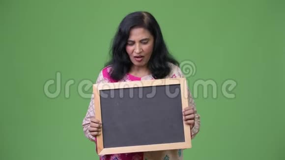 成熟快乐美丽的印度女人看黑板时很惊讶视频的预览图