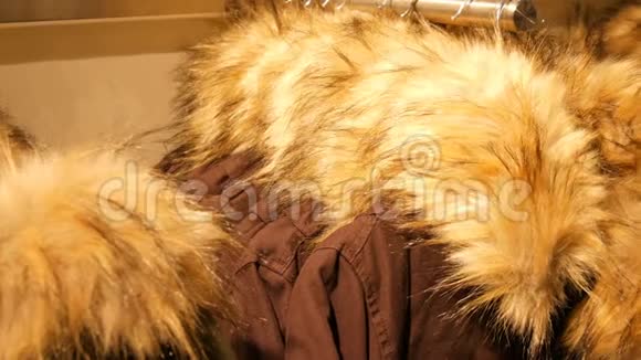 时尚温暖的冬季夹克毛皮领子挂在一家商场的服装店的衣架上视频的预览图