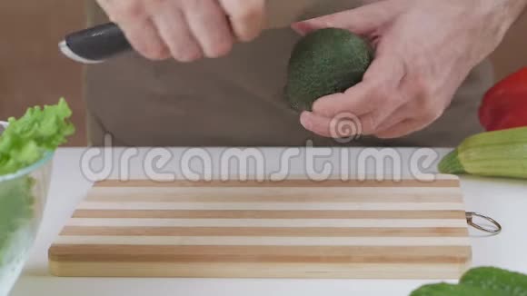 一个人用刀把鳄梨切成两半视频的预览图