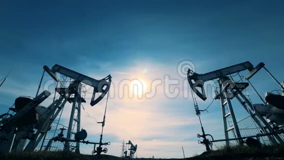阳光明媚的景观两个井架抽水汽油能源石油天然气燃油抽油机视频的预览图