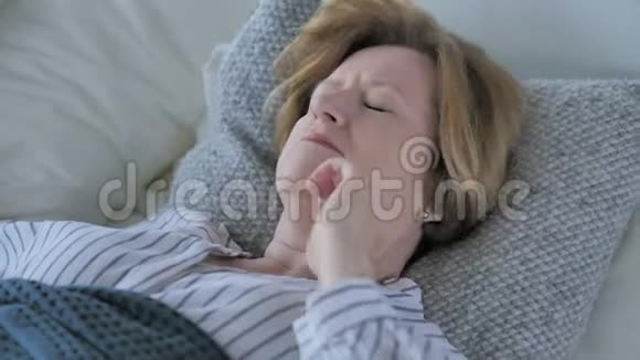 疲惫的老年妇女颈部疼痛睡在床上视频的预览图