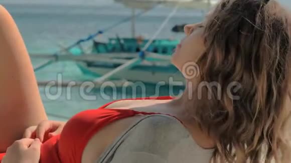 在炎热的夏日里快乐的年轻女子在热带沙滩上躺在吊床上休息视频的预览图