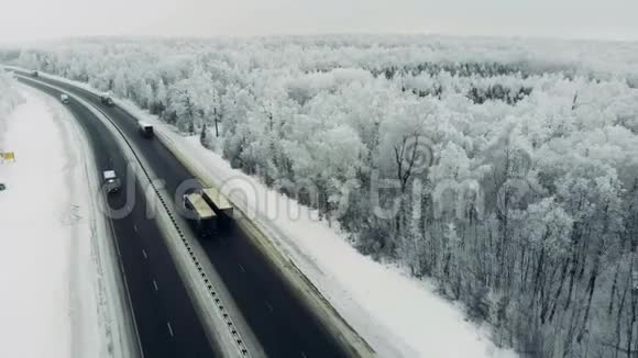 公路交通在冬季中在一个多风的寒冷的雪天视频的预览图