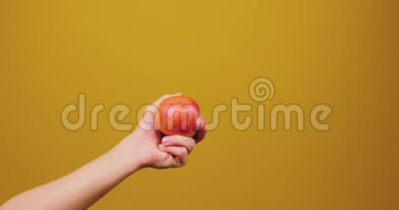 男手给了一个女人一个苹果孤立在黄色背景在工作室健康的生活方式水果健康视频的预览图