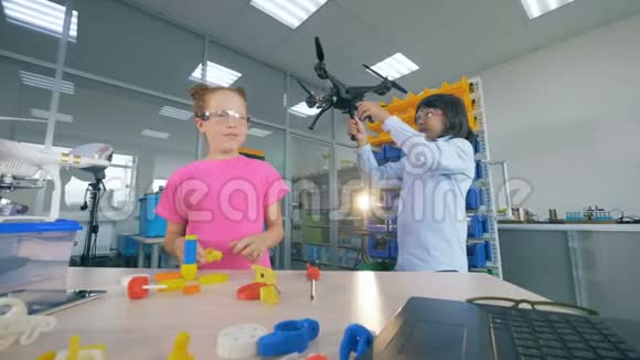 两个学校的孩子在现代技术学校课堂上固定无人机模型4K视频的预览图