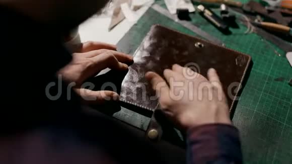手工制作皮夹的过程工匠在成品上涂上软化凝胶视频的预览图