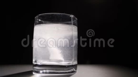 泡腾片溶于一杯热水中深色背景视频的预览图